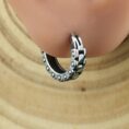 Обеца моторна верига от стомана за ухо върху дървена повърхност