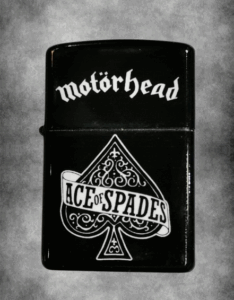 Черна бензинова запалка с бял дизайн на Асо Пика (Ace of Spades) и логото на Motörhead.