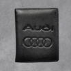 Черен кожен мъжки портфейл с релефно лого и надпис на марката Audi.